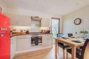 a kitchen and dining room with a table and a red refrigerator at Dobby Lodge in Bassenthwaite