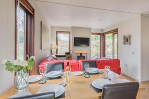 a dining room with a table and a red couch at Dobby Lodge in Bassenthwaite