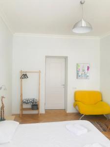 a bedroom with a yellow chair and a bed at Guest House Story in Tbilisi City