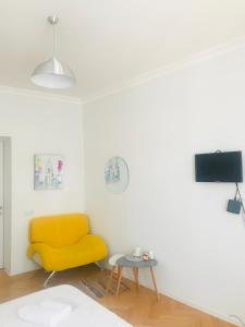 a living room with a yellow chair and a table at Guest House Story in Tbilisi City