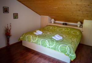 1 dormitorio con 1 cama verde y 2 toallas en Holiday Home Else, en Lovran
