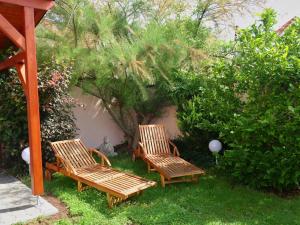 a group of three wooden chairs sitting in the grass at Penzion Na barokní cestě Wellness & Spa in Plasy