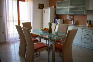 uma cozinha com uma mesa de vidro e cadeiras em Holiday Home Else em Lovran