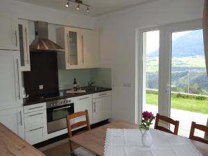 a kitchen with white cabinets and a table and a window at Apartment Barbara in Mutters