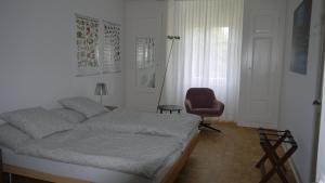 una camera con letto e sedia rossa di Habsburg B&B a Berna