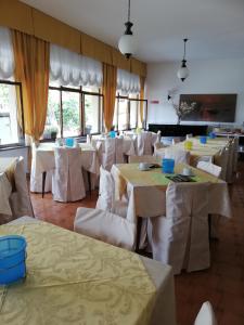 Hotel 2000 في غرافيدونا: غرفة طعام مع طاولات وكراسي بيضاء
