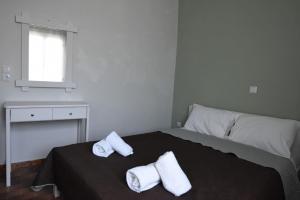 1 dormitorio con 1 cama con 2 toallas en Rodi Retro en Nauplia
