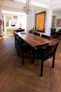 een eetkamer met een houten tafel en stoelen bij Habsburg B&B in Bern