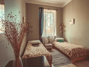 a small room with a bed and a window at Downtown Forest Hostel & Camping in Vilnius