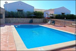 basen z dwoma krzesłami i dom w obiekcie Apartamento con piscina comunitaria w mieście Conil de la Frontera