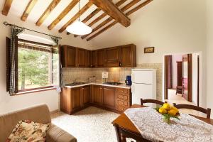 una cocina con armarios de madera y una mesa con un bol de fruta en Il Martellino, en Follonica