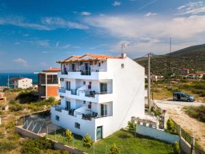 um edifício de apartamentos branco com vista para o oceano em Studios Evrika em Skala Marion