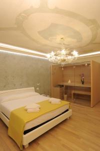 威尼斯的住宿－CA' XXII MARZO BOUTIQUE，一间卧室配有一张床和一个吊灯