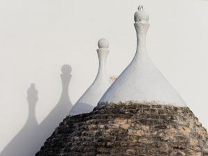 un primer plano de la parte superior de una botella de cristal con sus sombras en Terra Sessana Ville e Trullo con piscina privata, en Ostuni