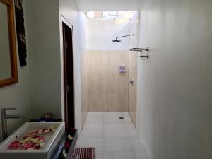 a bathroom with a shower and a bath tub at PITAMATA VILLAS in Nusa Penida