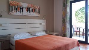 1 dormitorio con 1 cama con manta naranja en Rooms and Apartments Mofardin, en Rovinj