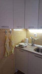 een keuken met een wastafel en een aanrecht met handdoeken bij Apartman Lucijan in Kaštela