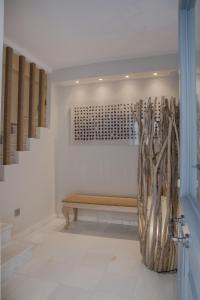 une pièce avec un banc et quelques branches sur le mur dans l'établissement Micra Anglia Boutique Hotel & Spa, à Andros