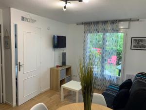 a living room with a couch and a table at FRONT DE MER 11 - JARDIN - THALASSO in Cabourg +7 photos