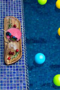 a tray of fruit on a table next to a swimming pool at Novotel Mohammedia in Mohammedia