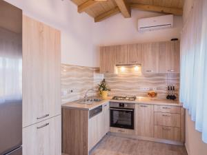 a kitchen with wooden cabinets and a stove top oven at Attractive Holiday Home with Pool bubble bath Patio Courtyard in Barbariga