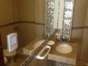 Un baño con dos lavabos y un inodoro. en Lorenzo Suites Hotel, en San Miguel de Tucumán 33 fotos más