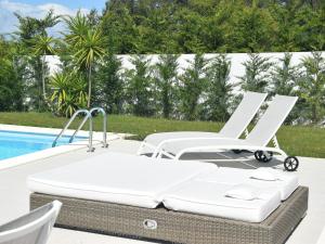 eine Terrasse mit 2 Stühlen und einem Pool in der Unterkunft Comfortable villa with private pool in Nadadouro in Nadadouro
