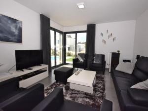 a living room with a couch and a tv at Lavish Villa in Foz do Arelho with Private Pool in Foz do Arelho