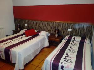 een hotelkamer met twee bedden en een rode laptop erop bij Hostal de la Villa Molinos in Molinos