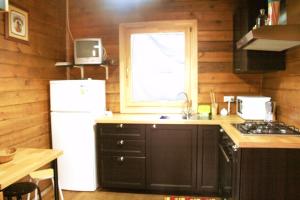 een keuken met een witte koelkast en een raam bij Casa de madera in A Coruña