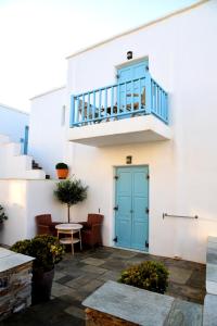 un edificio blanco con una puerta azul y escaleras en Hotel Messaria, en Kithnos
