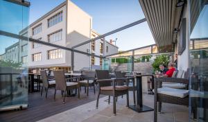 a patio with chairs and tables on a balcony at Hotel Park Drniš in Drniš
