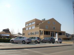 a building with cars parked in front of it at Garni Hotel BaMBiS in Podgorica