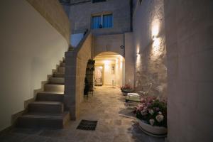 a hallway with stairs and flowers in a building at Albergo Del Sedile in Matera