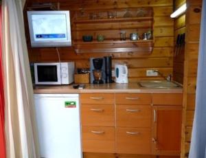 a kitchen with a microwave and a tv on the wall at Privatzimmer R. & R. Andersen in Lehnin
