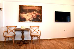 キスノスにあるHotel Messariaの絵画のある部屋にテーブルと椅子2脚