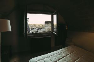 een slaapkamer met een raam met uitzicht op de stad bij Albergo Del Sedile in Matera