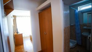 a bathroom with a wooden door and a toilet at Vila Argentinia (Aria Betul) in Saturn
