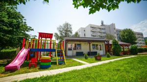 a playground with a slide in the grass at Vila Argentinia (Aria Betul) in Saturn +13 photos