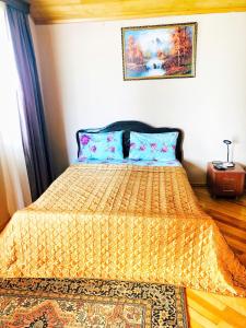 a bedroom with a bed with a yellow comforter at hotel Pharnavaz in Batumi