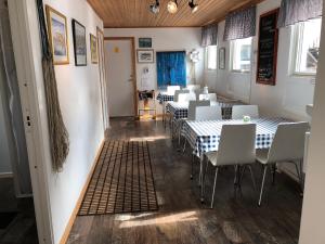 a dining room with tables and white chairs at Kajsa krabbat Vandrarhem in Kungshamn