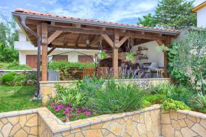 a wooden pergola in the backyard of a house at Apartments Stolfa in Krk