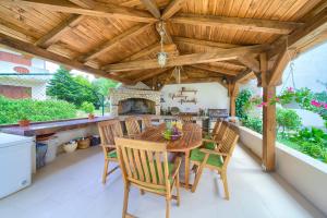 een eetkamer in de openlucht met een houten pergola bij Apartments Stolfa in Krk