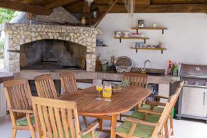 a wooden table in a kitchen with a fireplace at Apartments Stolfa in Krk +22 photos