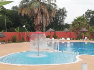 a fountain in the middle of a swimming pool at Mobile-Home in Argelès-sur-Mer