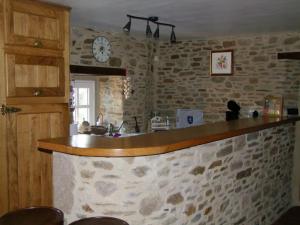 a kitchen with a counter and a clock on the wall at L'Tas De Cailloux in Cancale