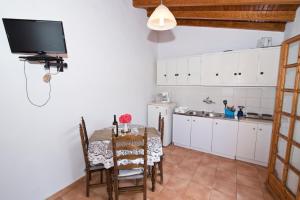a kitchen with a table and a tv on the wall at MOURAGIO in Kiparission