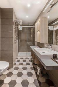 a bathroom with two sinks and a shower and a toilet at Metropole Hotel by Semarah in Rīga