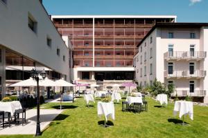 a group of tables and chairs with umbrellas in a courtyard at Morosani Schweizerhof in Davos
