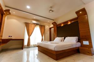 a bedroom with a large bed and a large window at SR Jungle Resort in Coimbatore